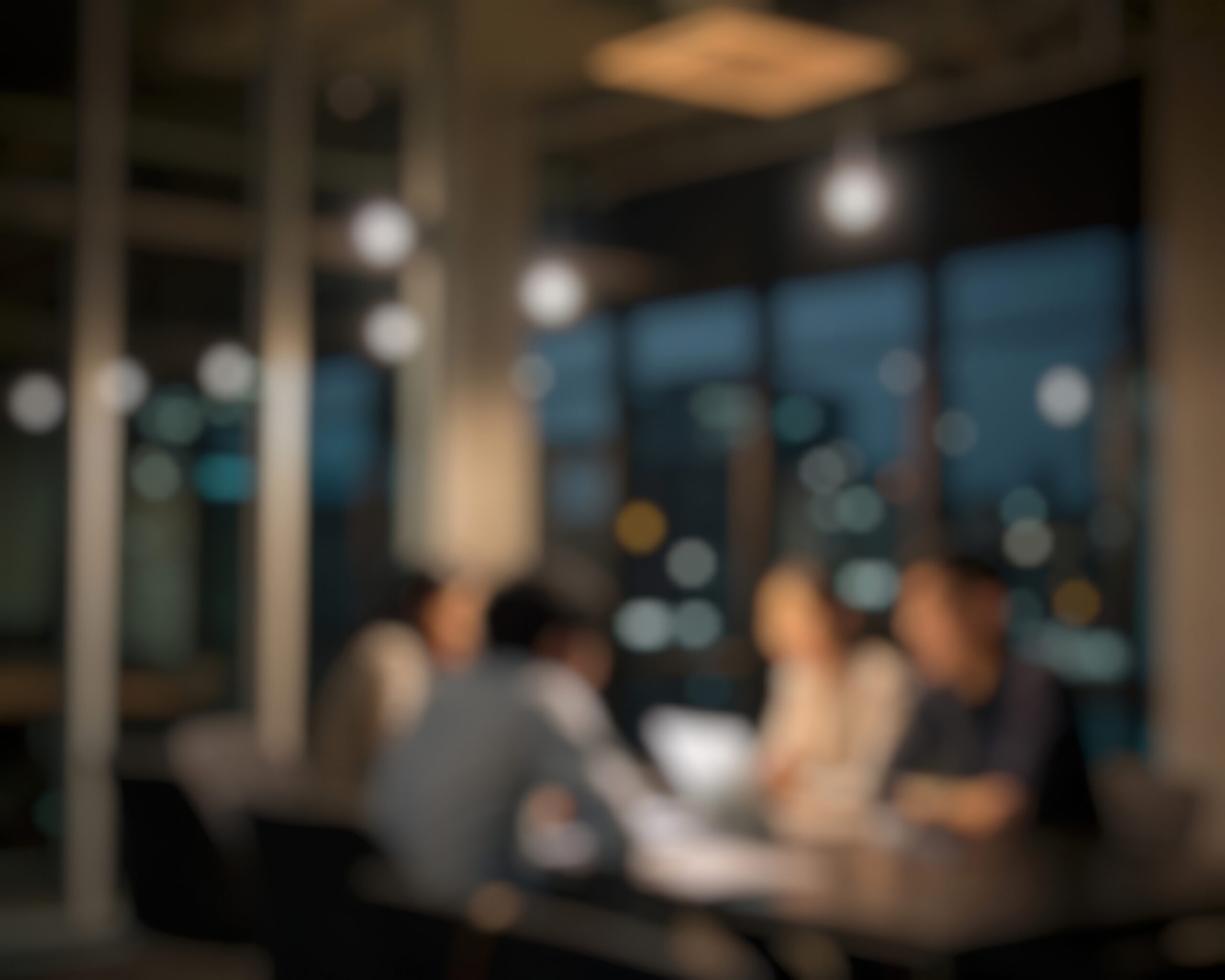 A team working together at a shared table in the evening.